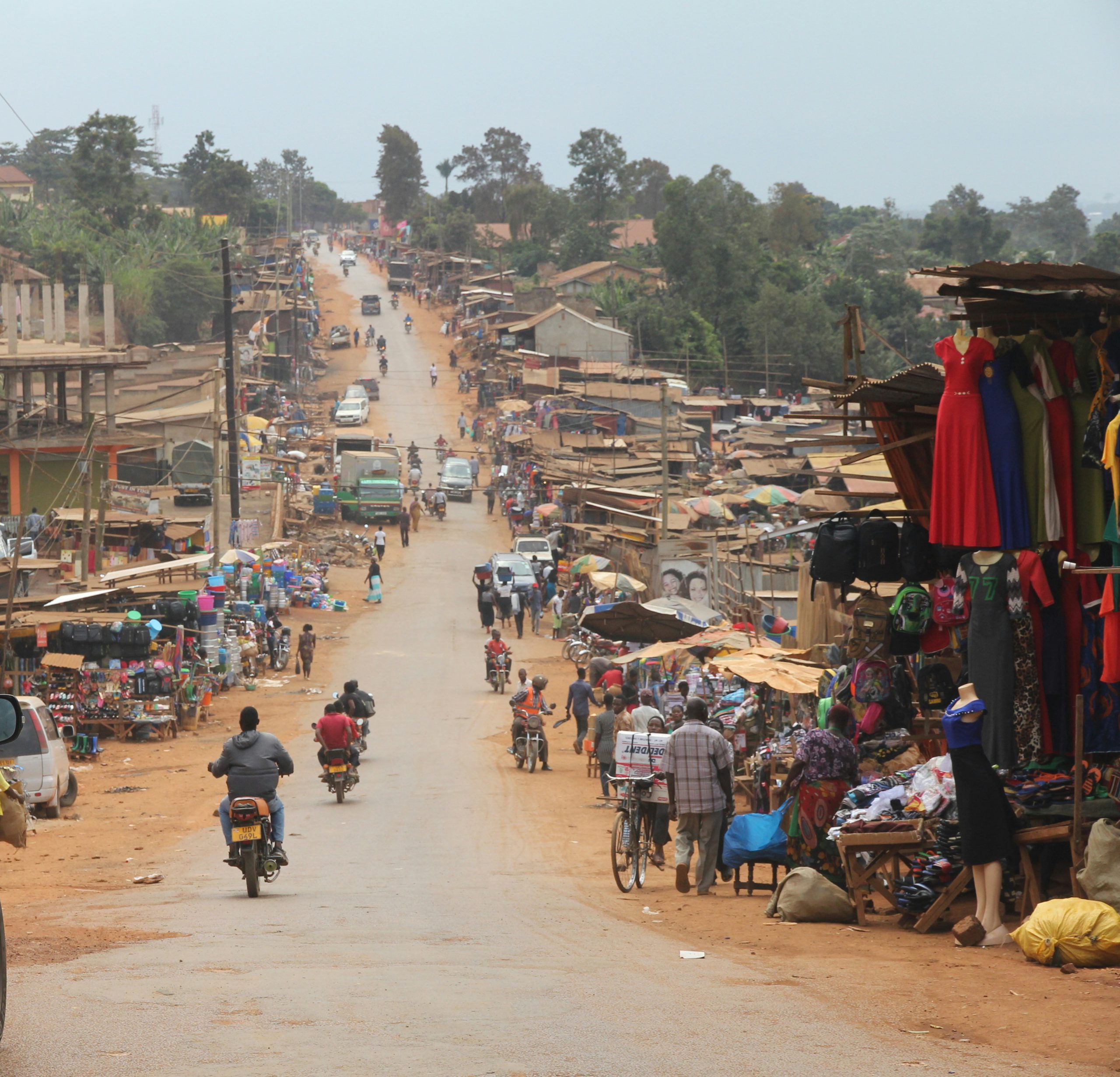Busy dirt road lined with market stalls